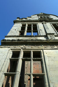 Low angle view of old building against clear blue sky