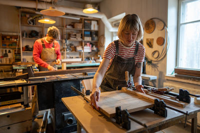 Side view of woman working at workshop