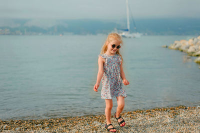 Full length of girl standing on sea shore