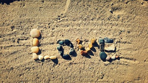 High angle view of love text made of stones on sand at desert