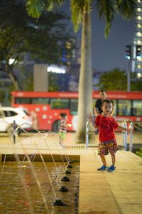 Rear view of girl playing on water