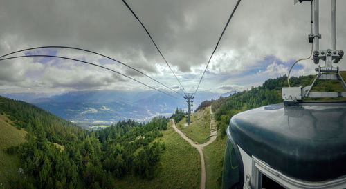 Low angle view of overhead cable car against sky