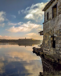 Scenic view of lake by building against sky