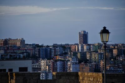 Buildings in city against cloudy sky