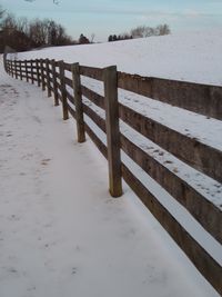 Wooden fence on snow covered land