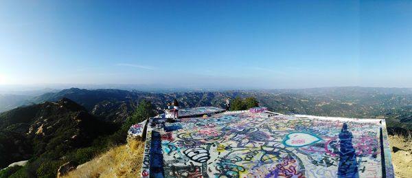 Panoramic view of landscape against blue sky with art graffiti 