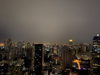 Illuminated buildings in city against sky at night