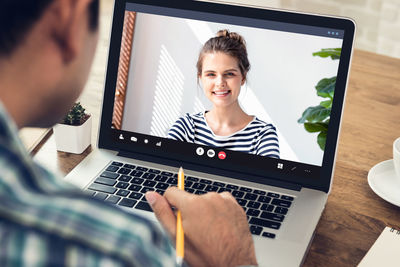 Midsection of man talking on video call at cafe