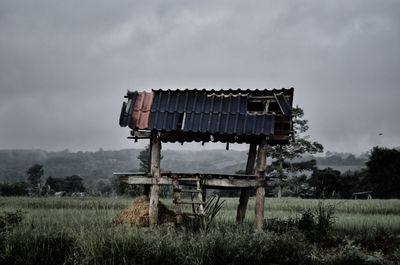 Old barn on field against sky