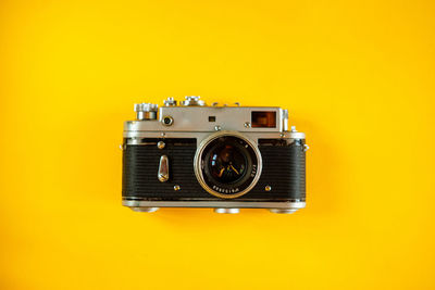 Close-up of camera against yellow background