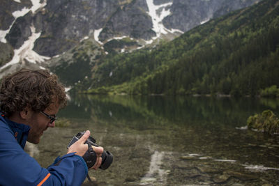 Man photographing at morskie oko lake