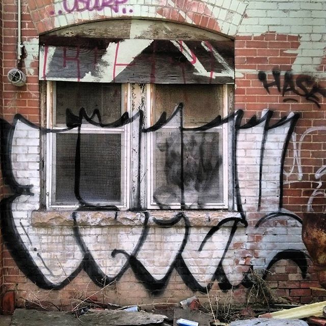 building exterior, architecture, built structure, window, brick wall, wall - building feature, graffiti, house, old, residential structure, wall, residential building, building, day, outdoors, no people, door, weathered, art and craft, low angle view