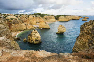 Rock formations by sea against sky