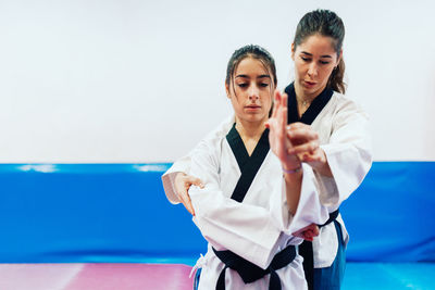 Young woman with instructor practicing martial arts