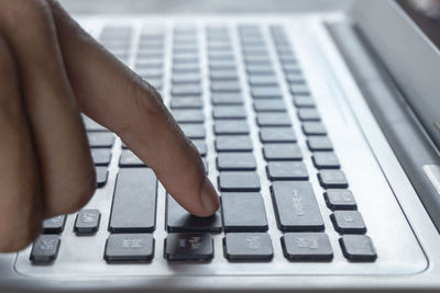 Close-up of hand using laptop