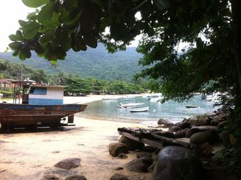 Boats moored on beach against sky