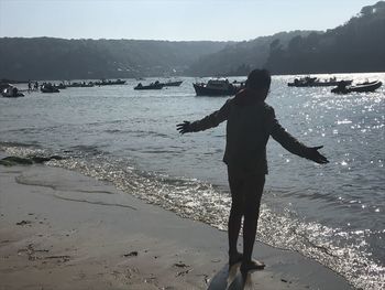 Woman standing at beach against sky