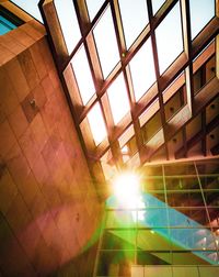 Low angle view of sunlight streaming through window on building
