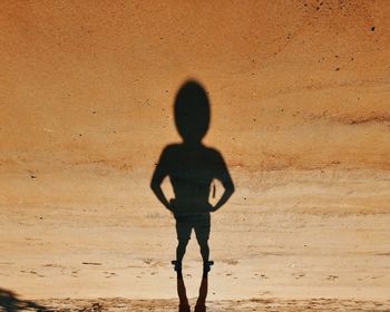 Full length of silhouette man standing on desert
