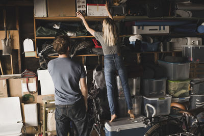 Man looking at woman while she adjusting boxes at home