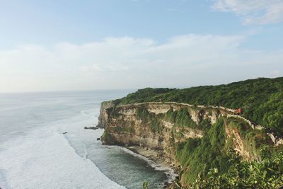 Scenic view of cliff by sea against sky