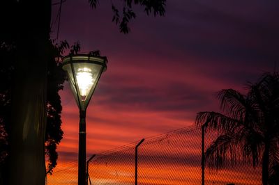 Low angle view of illuminated street light against sky during sunset