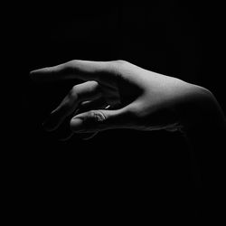 Close-up of human hand against black background