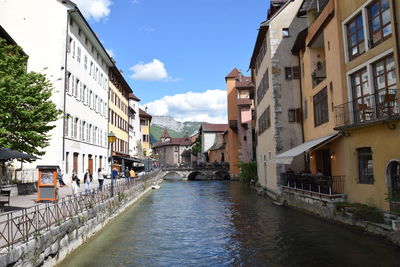 Canal amidst buildings in town against sky