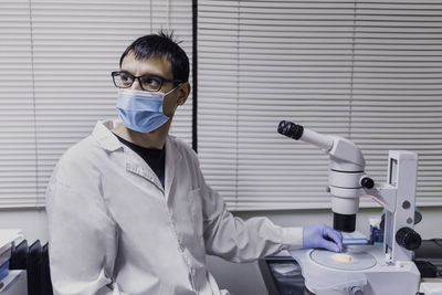 Male scientist using microscopy in laboratory