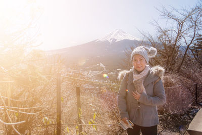 Portrait of smiling woman standing in snow