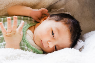 Portrait of cute baby lying on bed