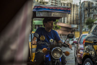 Man riding motorcycle on street in city