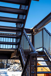 Low angle view of staircase by building against clear blue sky