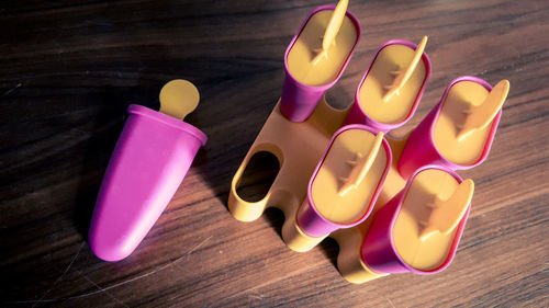 High angle view of flavored ice containers on table