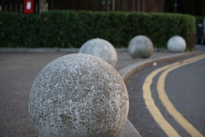 Spherical stones in row on sidewalk