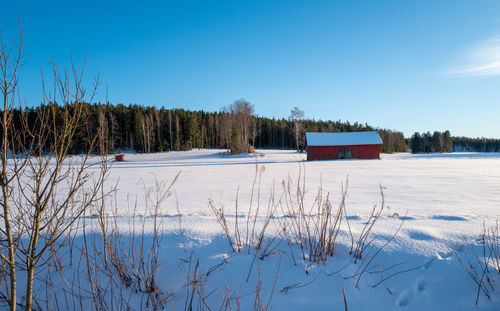 Scenic view of snow covered field against sky