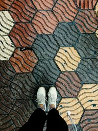 Low section of man standing on tiled floor