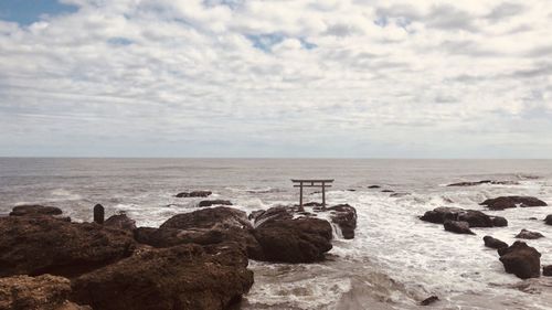 Rocks on sea shore against sky