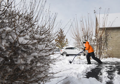 Adolescent boy shovelling snow off of driveway after a winter storm