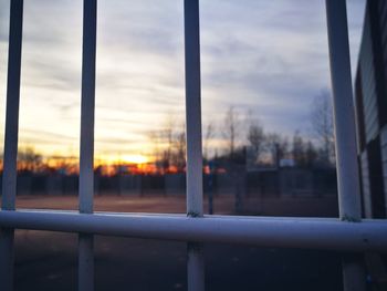 Close-up of railing against sky during sunset