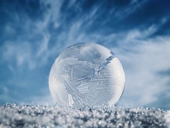 Close-up of snow globe against sky