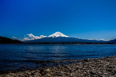 Scenic view of snowcapped mountains against blue sky