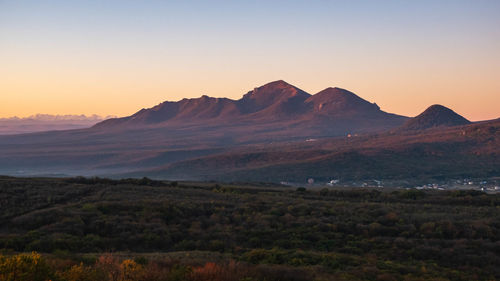 Scenic view of mountains against clear sky during sunset