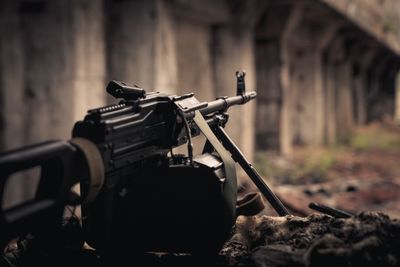 Close-up of gun aiming against built structure