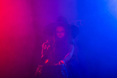 Young woman sitting on illuminated stage