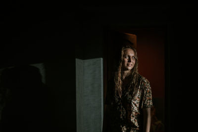 Young woman standing against wall