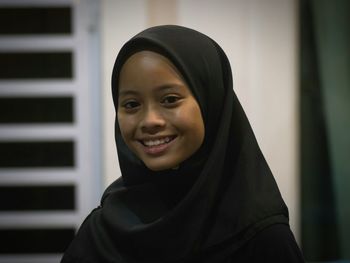 Close-up portrait of smiling girl wearing headscarf