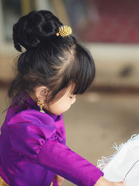 Side view of cute baby girl standing indoors