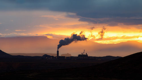 Silhouette of power plant at sunset