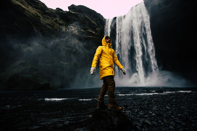 Man standing at waterfall